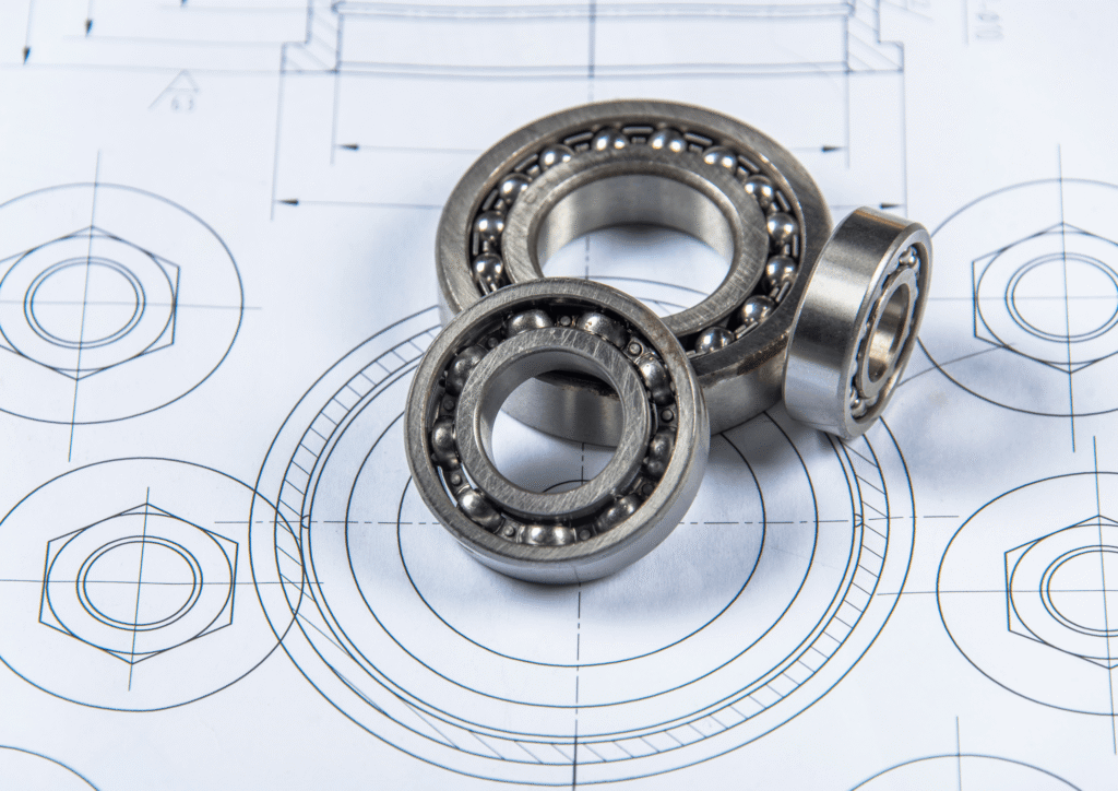 Close-up of ball bearings on engineering blueprints with circular diagrams.