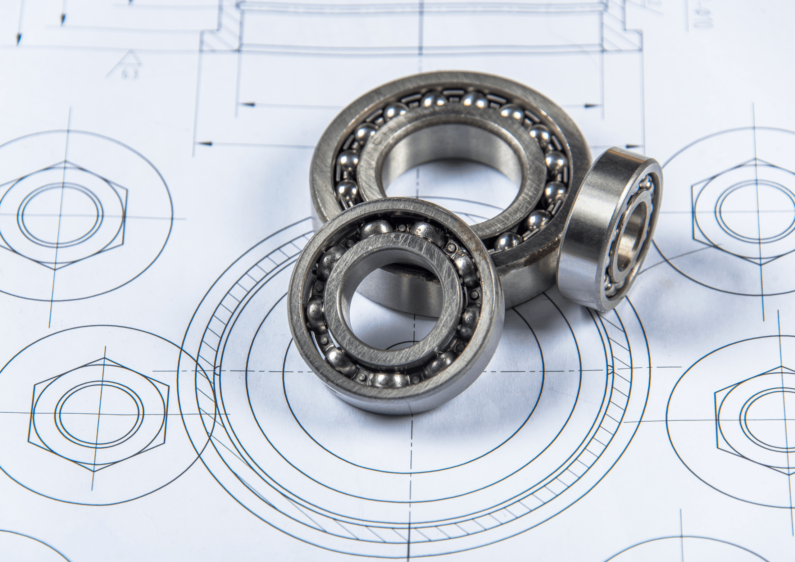 Close-up of ball bearings on engineering blueprints with circular diagrams.